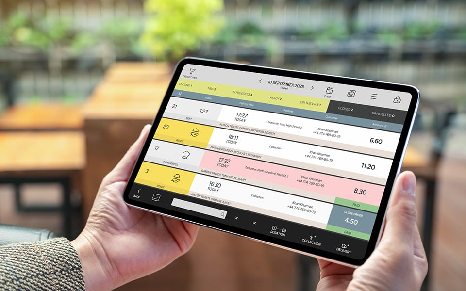 Restaurant staff managing delivery and takeaway orders on tablet in real time