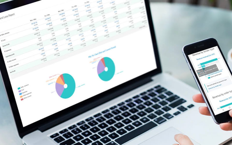 Restaurant manager reviewing orders report and sales analytics dashboard on laptop and mobile device
