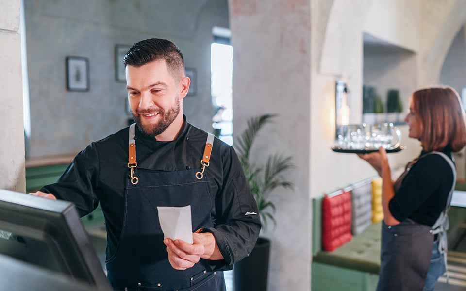 Restaurant staff processing orders and payments using POS system in real time