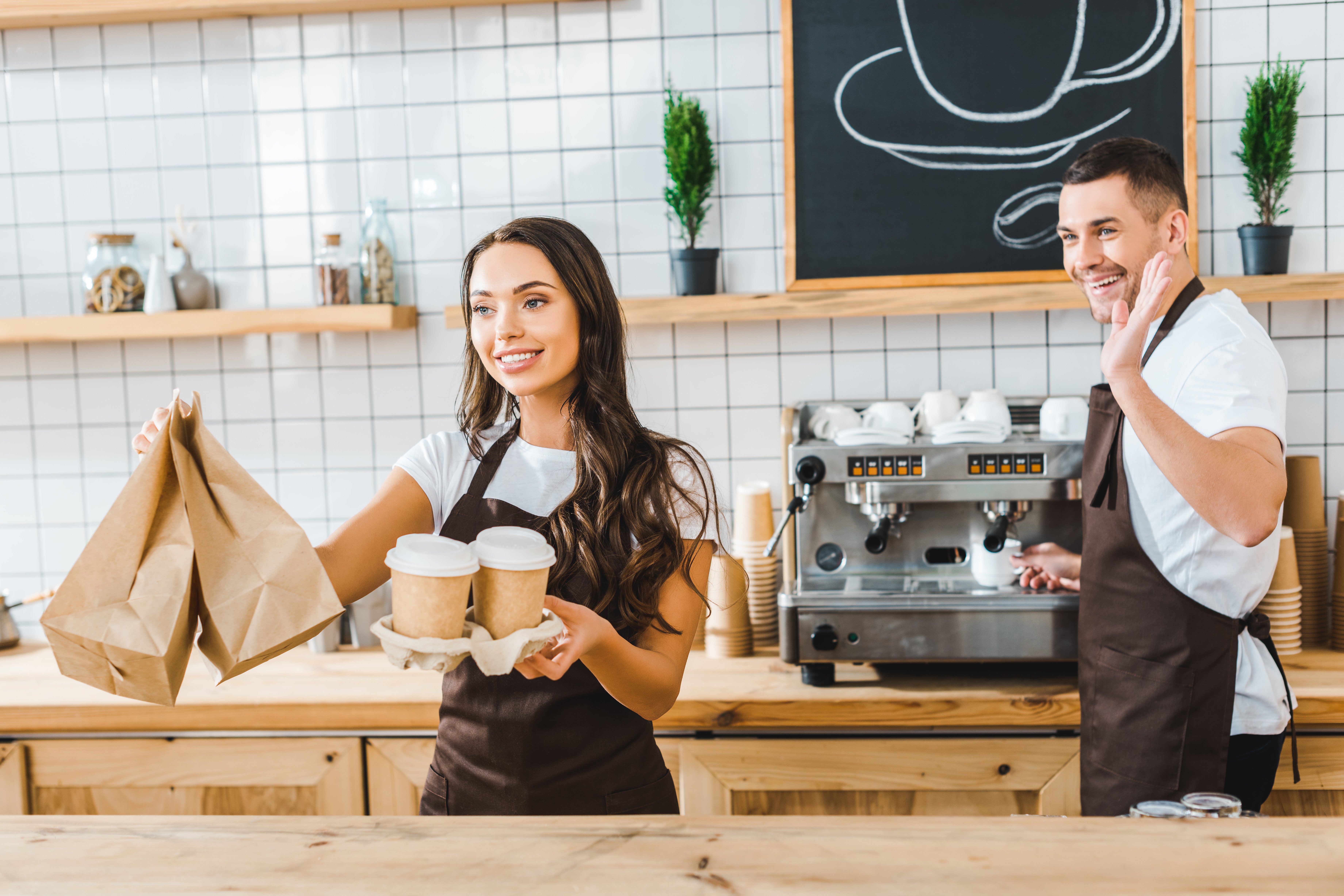 attractive-brunette-cashier-holding-paper-cups-and-2023-11-27-04-53-09-utc