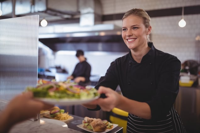 attractive-young-female-chef-giving-fresh-greek-sa-2023-11-27-05-11-34-utc