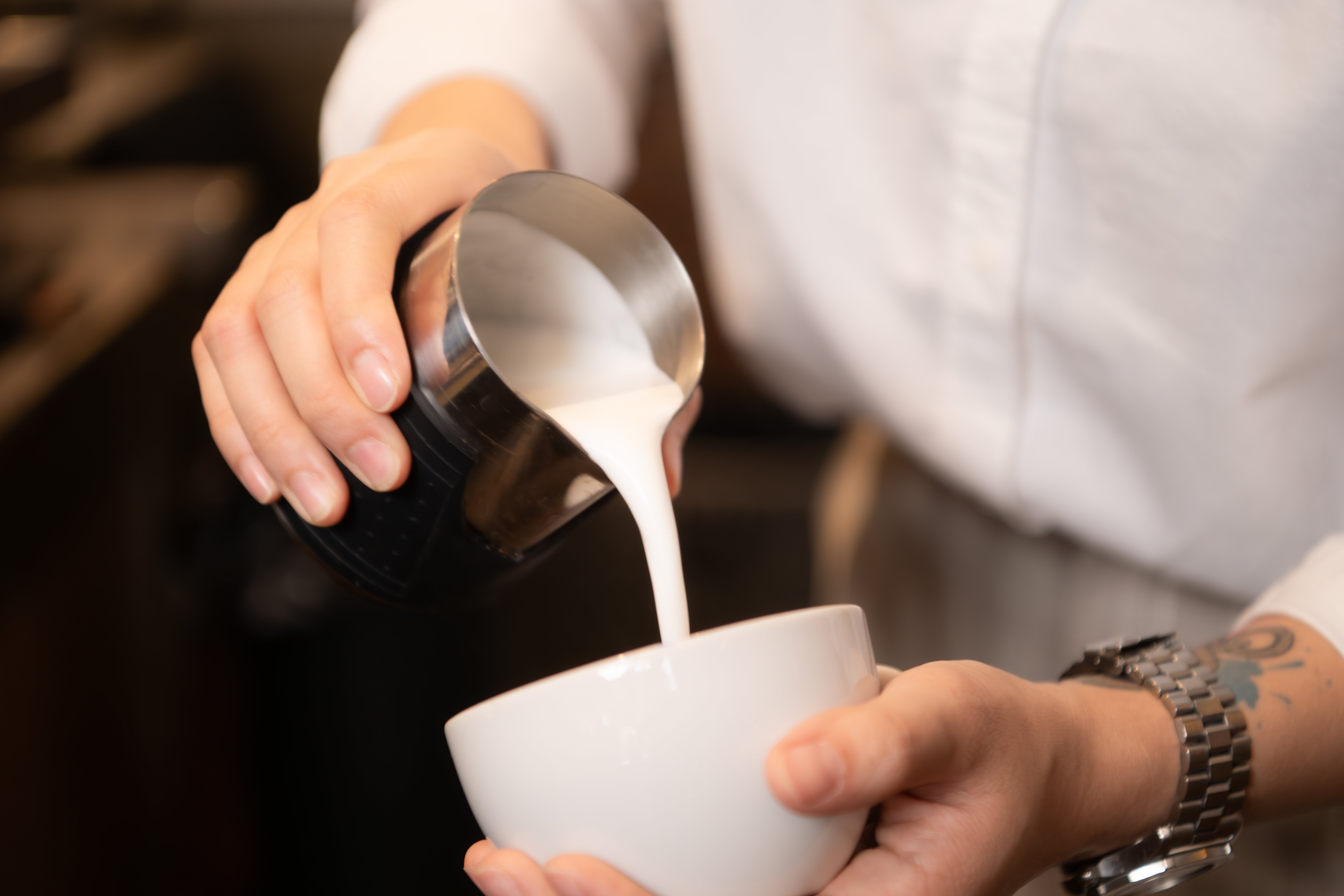 barista-pouring-coffee-into-a-cup-in-coffee-shop-2023-11-27-05-19-42-utc