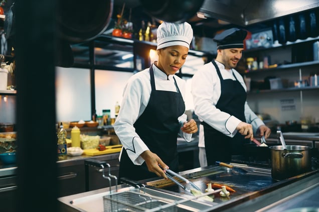 two-professional-cooks-preparing-meal-in-the-kitch-2023-11-27-04-54-52-utc