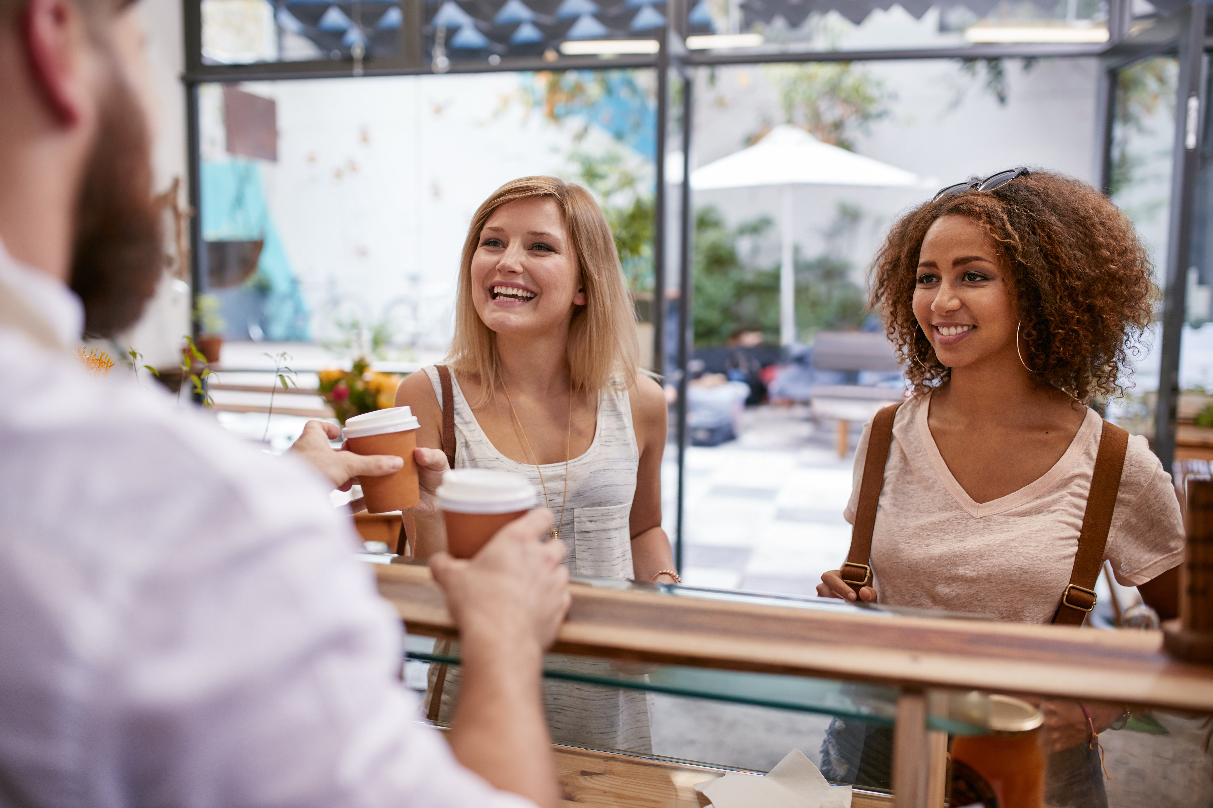 women-friends-receiving-their-hot-drinks-at-cafe-2023-11-27-05-01-25-utc
